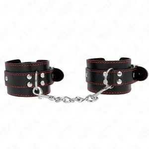 Schwarze Leder-Handfesseln mit roter Naht, verbunden durch eine silberne Kette.