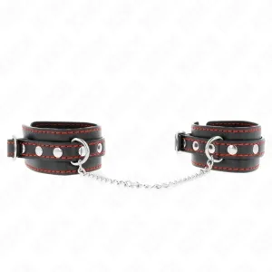 Schwarze Handfesseln mit roter Naht und silberner Kette, auf weißem Hintergrund.
