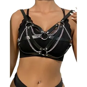 Frau trägt schwarzes Leder-Harness mit Ketten über einem schwarzen Top.