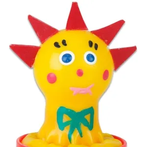 Gelbe Figur mit roten Zacken, blauen Augen und grüner Schleife, lächelt freundlich.