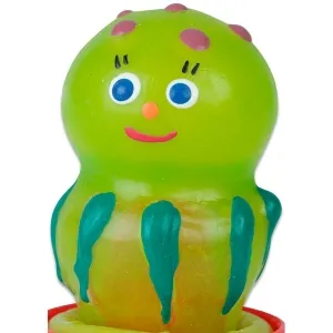 Green, smiling rubber figure with blue eyes, red dots and green stripes on a yellow base.