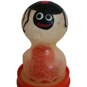 Toy figure with a round head, black hair and a red mouth on a red base.