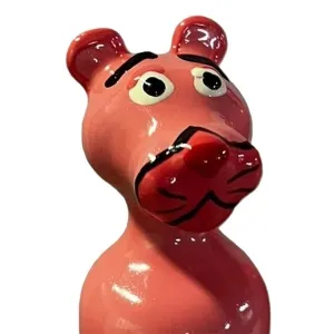 Pink ceramic figurine with large eyes and distinctive lips, reminiscent of a comic book character.