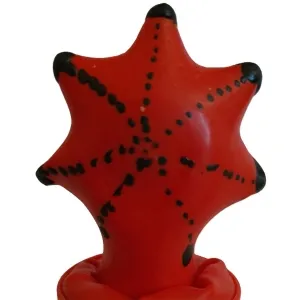Roter, sternförmiger Ball mit schwarzen Punkten und Spitzen, aufrecht stehend.
