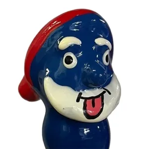 Blue cartoon character with a red hat, big eyes and a sticking-out tongue.