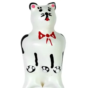White cat sculpture with red ribbon and black details, standing upright.