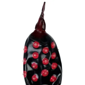 Schwarze Skulptur mit roten Punkten und spitzem Ende, erinnert an einen Marienkäfer.