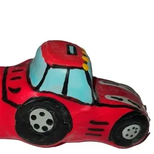 Rotes Spielzeugauto mit blauen Fenstern und schwarzen Rädern, seitliche Ansicht.