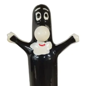 Schwarze Cartoonfigur mit großen Augen, weißem Gesicht und erhobenen Armen, trägt ein weißes Lätzchen mit rotem Lächeln.