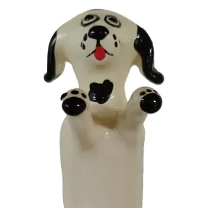 Keramikfigur eines Hundes mit schwarzen Ohren und Pfoten, roter Zunge und großen Augen.