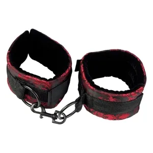 Schwarze und rote Handfesseln mit Schnallen und Haken, auf weißem Hintergrund.