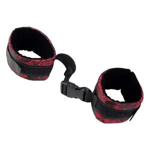 Black and red handcuffs with buckle closure, connected by a short strap.
