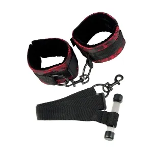 Black and red handcuffs with connecting strap and carabiner hook on a white background.