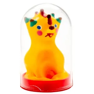 Yellow clay figure with a colorful face and crown in a transparent dome on a red base.