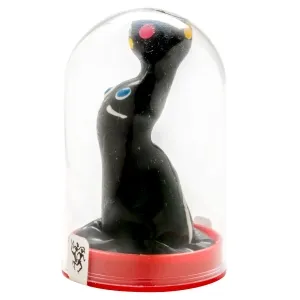 Black figure with colorful dots under a glass dome on a red base.