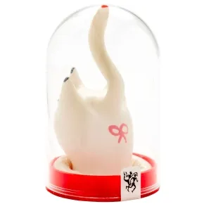 Weiße Katzenfigur mit erhobenem Schwanz in einer durchsichtigen Kuppel, roter Sockel, rosa Schleife auf der Seite.