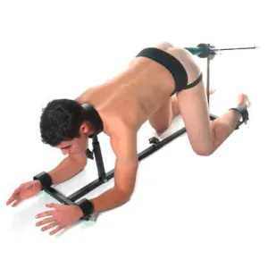 Person in BDSM gear on all fours, with restraints on wrists and ankles, fixed to a metal frame.